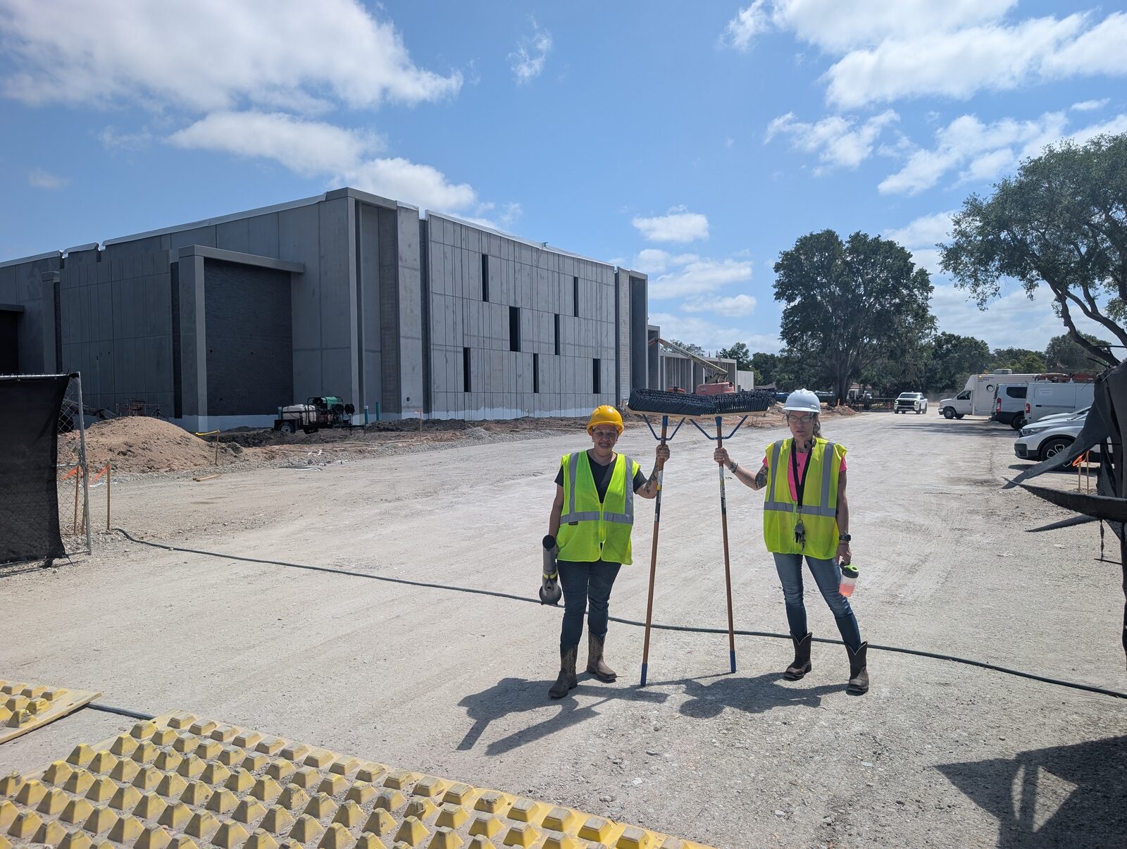 Orchid Cleaning crew in safety vests and hard hats sweeping a commercial warehouse floor